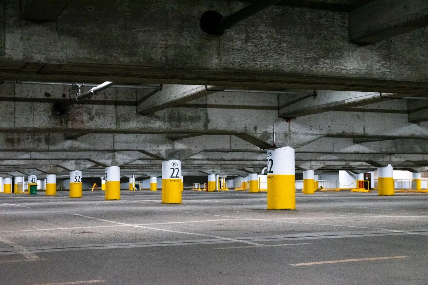 Parking cubierto con pilares señalizados en amarillo y suelo pintado